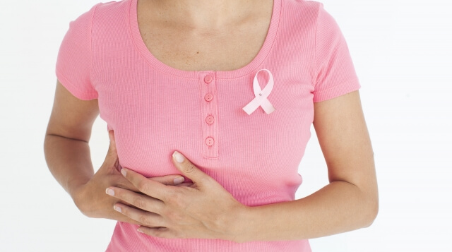 乳がんで、右胸を抑える女性