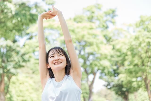 新緑の中で気持ちよく動く女性